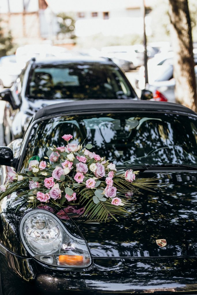 Hochzeitsplanung Nina Hübner Göttingen Schwarzes Auto mit buntem Blumenarrangement auf der Motorhaube.
